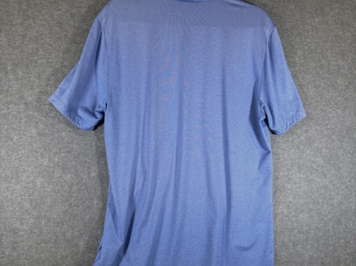 Before: the back of a blue polo photographed on a gray carpet
